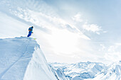 Junger Skifahrer steht auf einem Berggipfel, Gudauri, Mzcheta-Mtianeti, Georgien