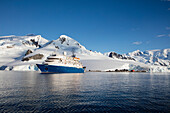 Expeditions Kreuzfahrtschiff MV Sea Spirit (Poseidon Expeditions) vor schneebedeckten Bergen, Paradise Harbor (Paradise Bay), Danco-Küste, Grahamland, Antarktische Halbinsel, Antarktis