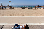Woman sunning on the Tayelet (beach promenade), Tel-Aviv, Israel