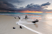 Karibische Sonnenuntergang Frames Baumstämme auf Ffryes Beach, Antigua, Antigua und Barbuda, Leeward Inseln, Westindische Inseln, Karibik, Mittelamerika