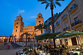 People dining in Piazza Duomo in front of the Norman Cathedral of Cefalu illuminated at night, Cefalu, Sicily, Italy, Europe