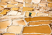 Woman mining salt, Salineras de Maras, Maras Salt Flats, Sacred Valley, Peru, South America