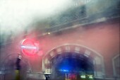 Close-up of an Undeground station entrance from bus window on a rainy day. King's Cross St. Pancras, Euston, London, England