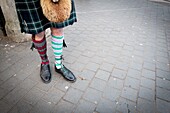 Unrecognizable man wearing typical Scottish costume and 'odd socks'. London, England