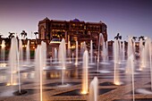 UAE, Abu Dhabi, Emirates Palace Hotel and fountains, dusk.