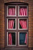 Red curtains in a window.