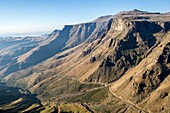Landscape of mountain ranges and dirt road running through Lesotho, Africa.