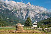 Looking across the village of Theth with its shingle roofed church and the Albanian Alps, Radohima massif and Mount Arapit in the background, Northern Albania.