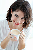 Porträt einer Frau, die eine Tasse Kaffee hält
