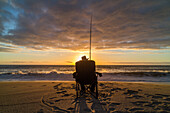 fisherman sitting in camping chairs on beach, sunset, west coast, Hokitika, South Island, New Zealand