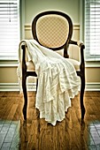 White dress on a chair in an empty room.