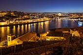 Dawn in Porto, Portugal. Looking along river Douro towards Luiz I Bridge.