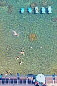 Tourists swimming in the clear waters of Tyrrhenian Sea, Amalfi Coast, Campania, Italy, Europe.