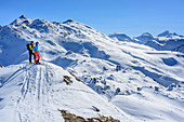 Woman and man backcountry skiing looking at mountains, Tuxer Alps in background, Rosslaufspitze, Tuxer Alps, Tyrol, Austria