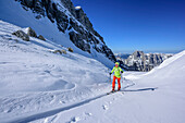 Frau auf Skitour steigt zur Hochfeldscharte auf, Reiteralm im Hintergrund, Sittersbachtal, Hochfeldscharte, Nationalpark Berchtesgaden, Berchtesgadener Alpen, Oberbayern, Bayern, Deutschland