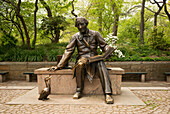 'Statue of Hans Christian Anderson sitting on a bench reading a book in Central Park; New York City, New York, United States of America'