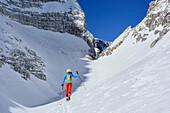 Woman backcountry skiing ascending towards Forcella Lavinal dell' Orso, Julian Alps, Friaul, Italy