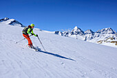 Woman backcountry skiing descending from Cima Marmotta, Zufallspitzen, Koenigsspitze, Zebru and Ortler in background, Cima Marmotta, valley Martelltal, Ortler range, Vinschgau, South Tyrol, Italy