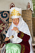 Kazakh woman spinning wool, Kazakh ethnographical village Aul Gunny, Talgar city, Almaty, Kazakhstan, Central Asia, Asia