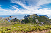 Steep road of curves in between green meadows and sea, Sorland, Vaeroy Island, county of Nordland, Lofoten Islands, Norway, Scandinavia, Europe