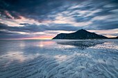 Midnight sun and clouds reflected in the clear water of sea Skagsanden, Flakstad, Nordland county, Lofoten Islands, Norway, Scandinavia, Europe