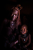 Himba family depicted in their dark hut