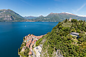 Aerial view of the green hill and castle overlooking Varenna surrounded by Lake Como Lecco Province Lombardy Italy Europe