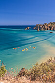 Canoes in the turquoise water of the Atlantic Ocean surrounding Praia Dona Ana beach Lagos Algarve Portugal Europe