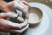 Close-up of creative hands using clay to create pottery