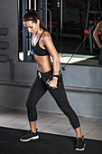 Determined young woman working out in gym