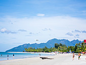 People enjoying at beach in Pulau Langkawi against sky