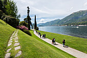 Tourists walking through the paths of the gardens of Villa Melzi d'Eril in Bellagio, Lake Como, Lombardy, Italy