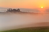 A farmhouse and hills of the Val d'Orcia, between the morning fog, val d'orcia, tuscany, italy, europe