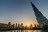 The Burj Khalifa skyscraper, its lake and the skyline of Dubai at the sunset, United Arab Emirates