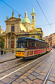 A tram runs on its rails in the historical center of Milan, Italy