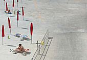 High angle view of women sunbathing at beach during sunny day