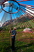 Kyrgyzstan, Issyk Kul Province (Ysyk-Kol), Juuku valley, setting up the yurt, Tourar Ousounbaev supports the wood structure of the roof of the yurt (tunduk) to plant the sticks that will make the final roof structure