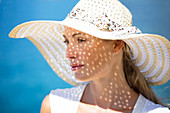 Close-up of a young woman wearing a sunhat.