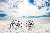 Typical beach cruiser bikes on white beach at the Gulf of Mexico, Fort Myers Beach, Florida, USA