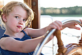 Young girl at the steering wheel, houseboat tour, Lake Mirower See, Kuhnle-Tours, Mecklenburg lakes, Mecklenburg lake district, MR, Mirow, Mecklenburg-West Pomerania, Germany, Europe