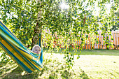 Little girl in a hammock, garden, trees, summer, Mecklenburg lake district, MR, MR, Schwaan, Mecklenburg-West Pomerania, Germany, Europe