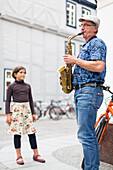 Straßenmusiker in der Altstadt von Schwerin, Saxophonist, Kind hört zu, Mecklenburgische Seenplatte, Schwerin, Mecklenburg-Vorpommern, Deutschland, Europa