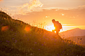 Junge Frau wandert auf den Muttlerkopf in den Alpen bei Sonnenaufgang