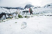Junge Frau wandert durch den letzten Schnee auf den Muttlerkopf in den Alpen