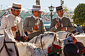 men on horseback with sherry glasses, Feria de Abril, Seville Fair, spring festival, Sevilla, Seville, Andalucia, Spain, Europe