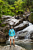 Portrait Of A Woman Standing In Front Of A Waterfall And Creek