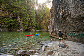 Two Packrafters Paddle The Chehalis River While Climbers Tackle A Rock Wall Beside The Chehalis River