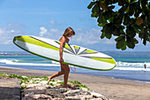 Surfer Girl With Surfboard Walking On The Beach
