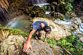 Man Rock Climbing Near Waterfalls And Pools On Java