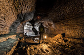Female Hiker Hiking Inside The Ape Cave Lava Tube In Washington, Usa